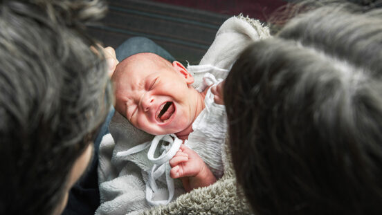 Newborn baby colic close up. Young parents and crying baby 1 month old.