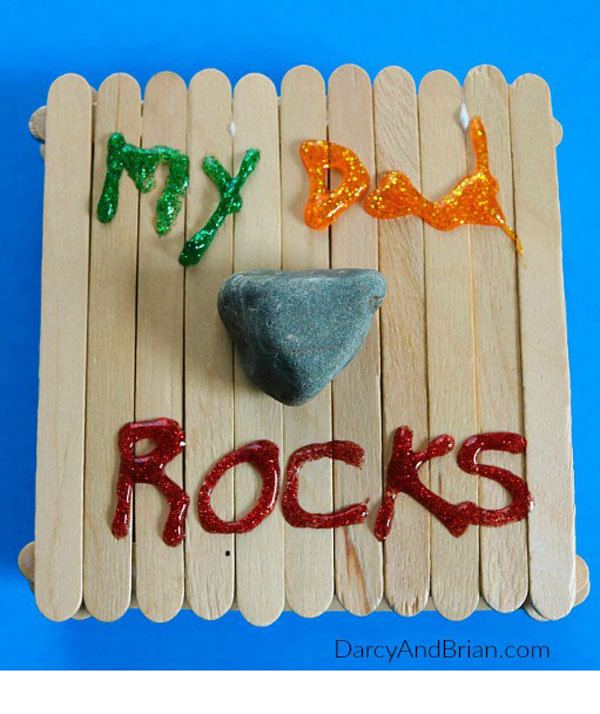 Paddlepop lolly sticks glued together, with a small rock stuck to the middle, and the words My Dad Rocks written on it in different colours