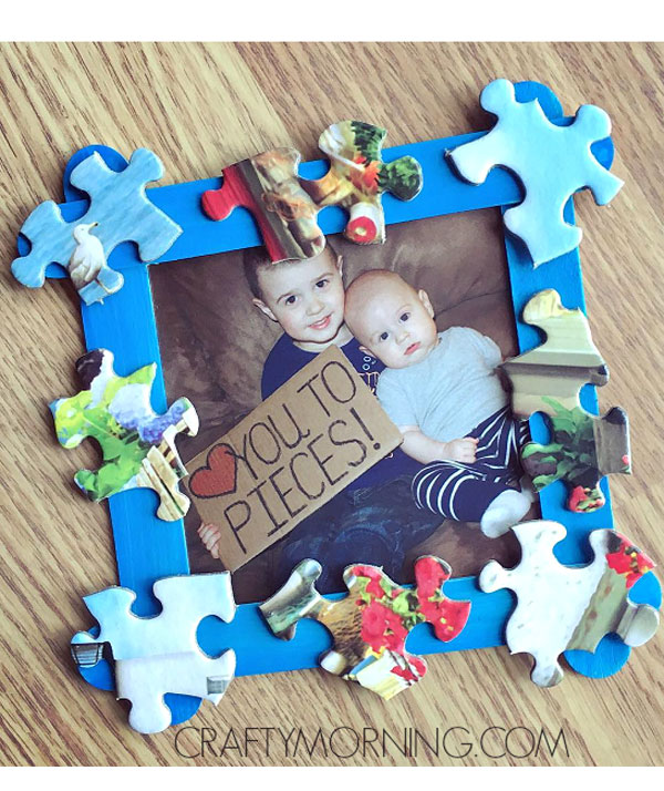 Blue photo frame with jigsaw pieces stuck on it and a photo of two young kids inside