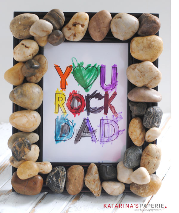 Frame made out of small smooth rocks with the coloured-in words YOU ROCK, DAD in the middle