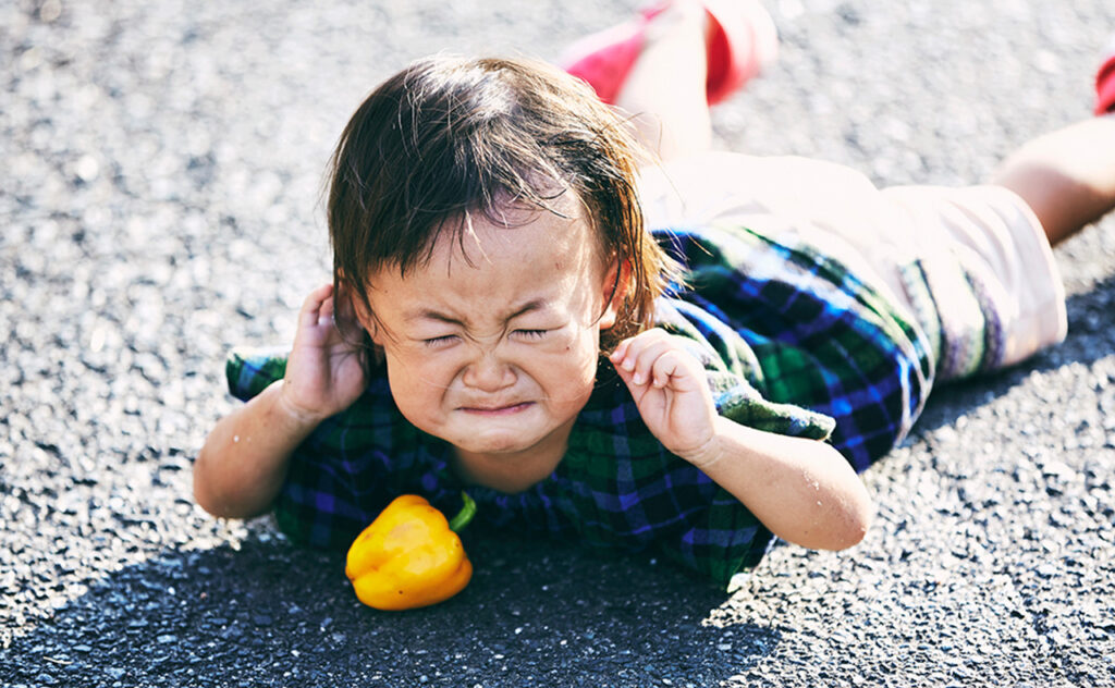 Little girl falling down and crying on the road