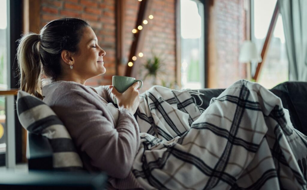 Woman/ mother laying on lounge having a cup of coffee or tea