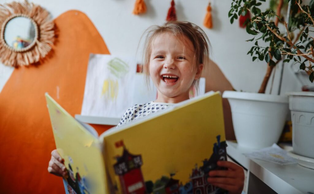 5-Year-Old Girl Enjoys Reading a Book in Her Room at Home.