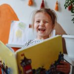 5-Year-Old Girl Enjoys Reading a Book in Her Room at Home.