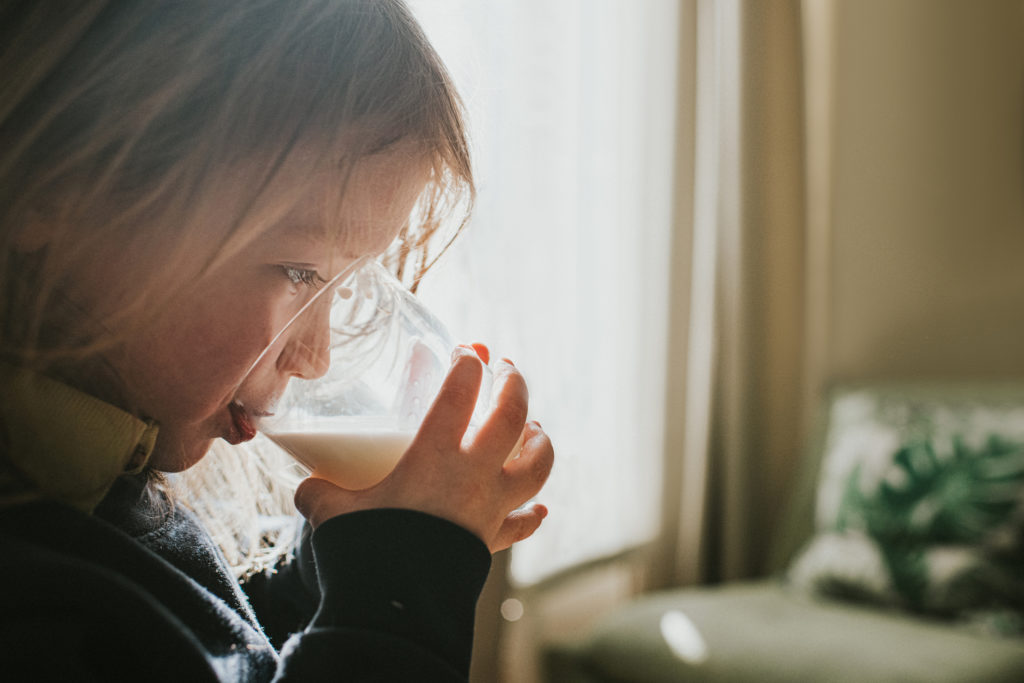 Cute preschool child drinking a glass of milk.