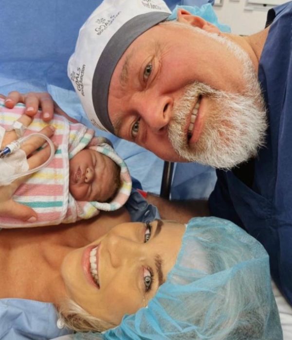 Kyle Sandilands and Tegan Kynaston with newborn son Otto in hospital gowns