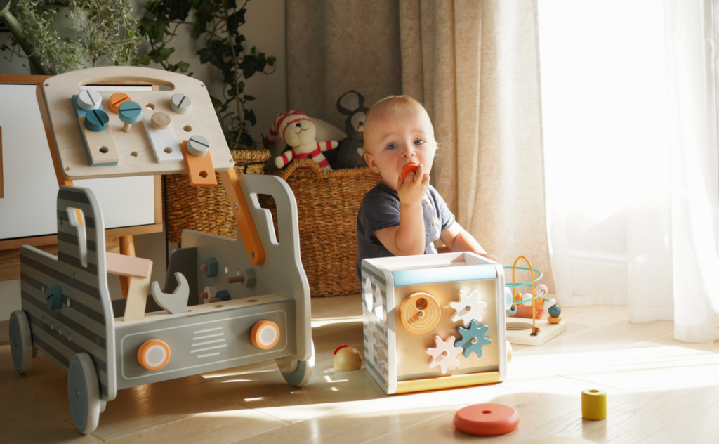 Toddler with Montessori style wooden toys on the floor around them