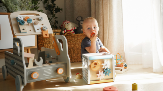 Toddler with Montessori style wooden toys on the floor around them