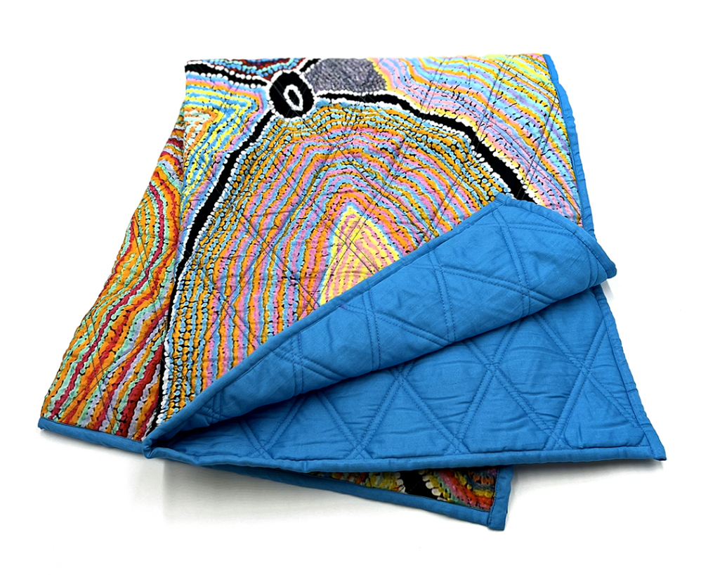 Folded blue and patterned Better World Aboriginal Art Quilted Baby Blanket