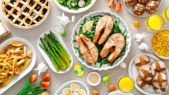 Easter festive table with salmon, asparagus, salad, potato, muffins and berry pie