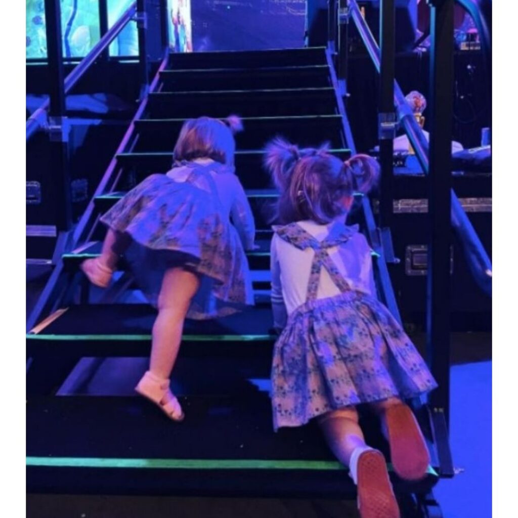 Lulu and Lottie climbing up the stairs to the Wiggles stage