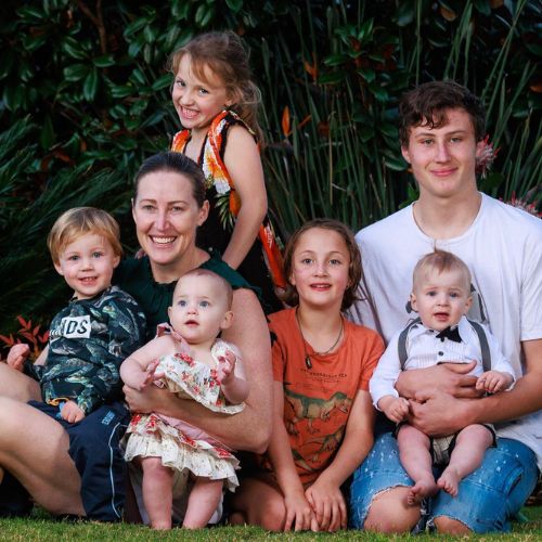 Jana Pittamen sitting on the grass  her six children, all smiling