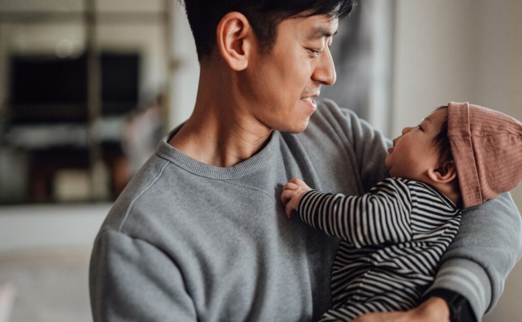 Dad looking at baby as they cuddle