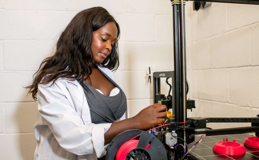 Woman wearing Tommee Tippee Wearable Breast Pump while working on a techinical machine at work