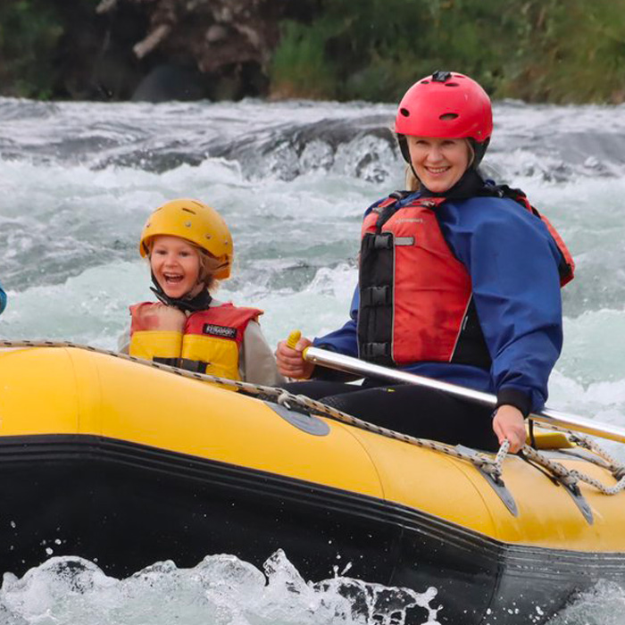 A mother and child smile broadly as they enjoy Family Rafting on the Tongariro River in New Zealand's North Island.