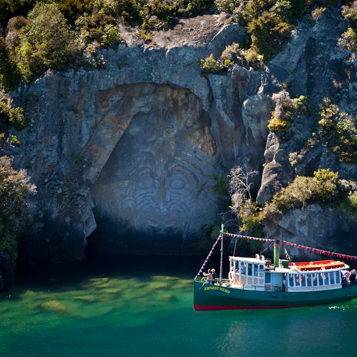 Ernest Kemp, a replica steamboat is pictures floating in front of a beautiful rocky cliff in New Zealand's North Island.