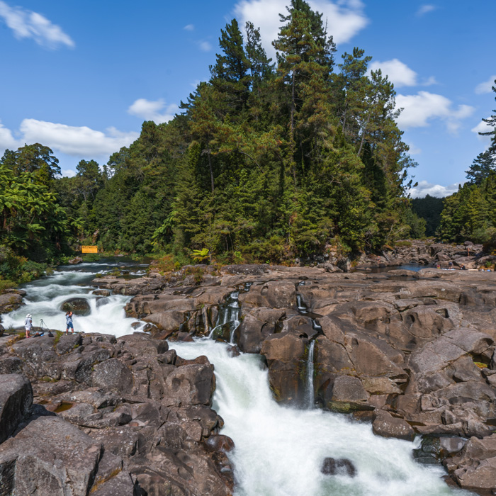 A cinematic image of a waterfall cascading down rocks at Lake McLaren's McLaren's falls in New Zealand's North Island.