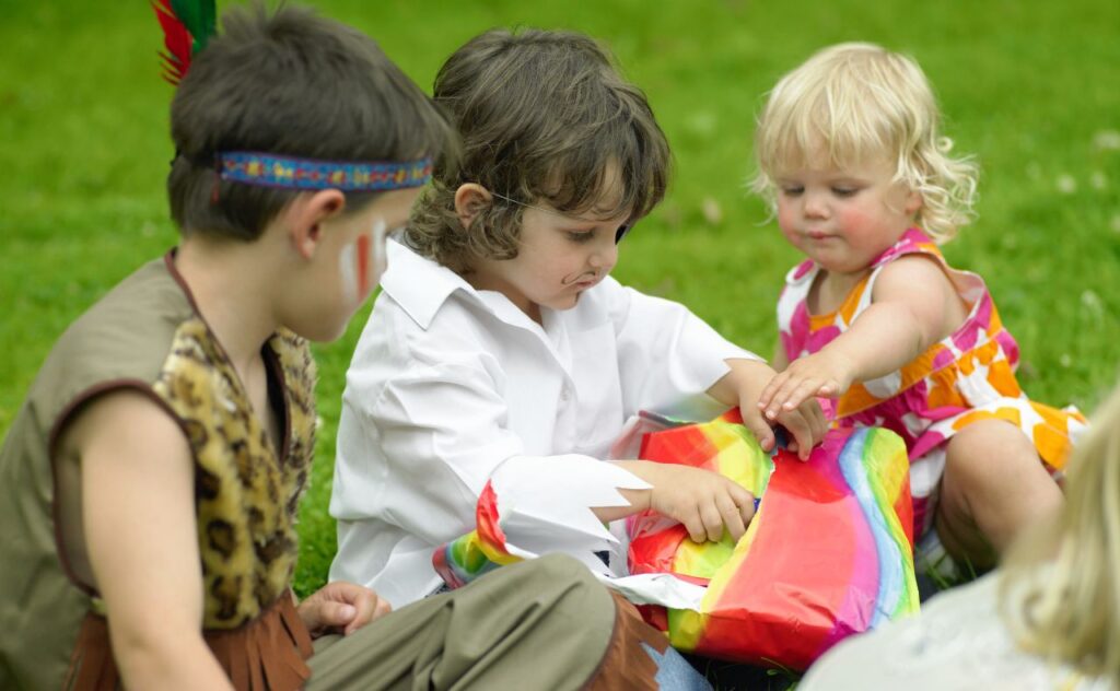 Kids unwrapping Pass the Parcel party game