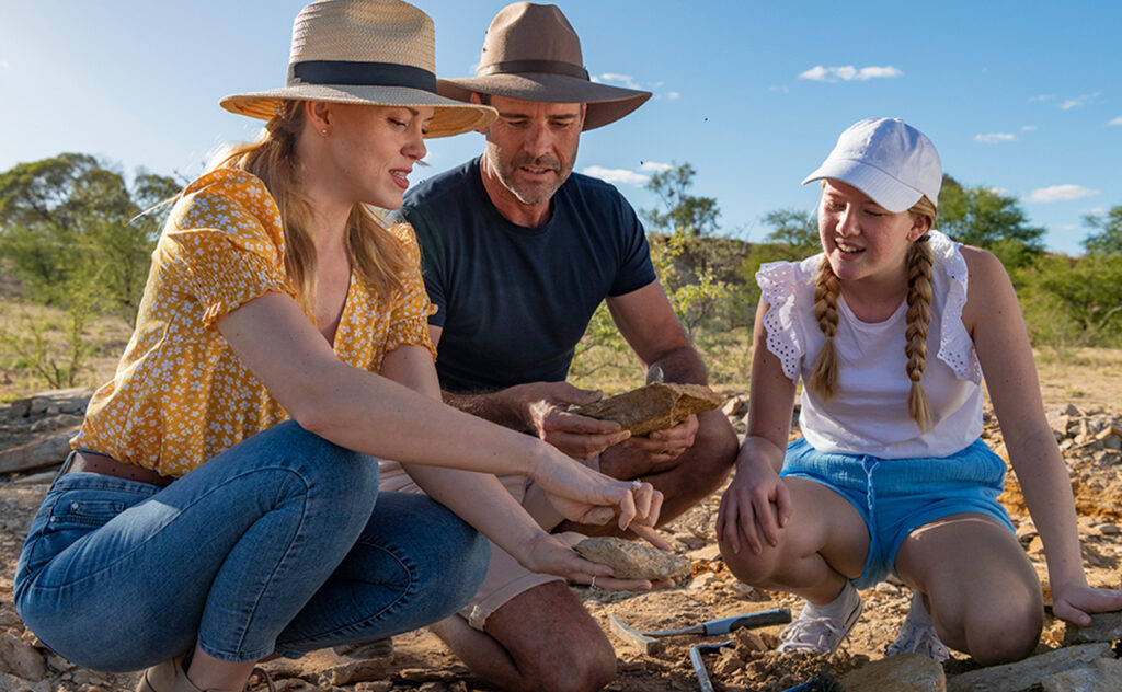 A family digs in the dirt for fossils at Kronosaurus Korner in North West Queensland.