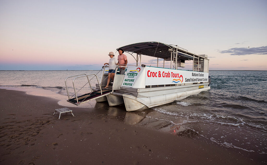 A couple dismount a boat after a Croc and Crab Tour in North West Queensland.