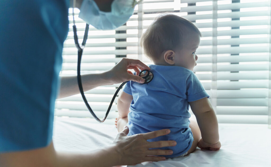 Young toddler boy receives medical attention as doctor performs health checks.