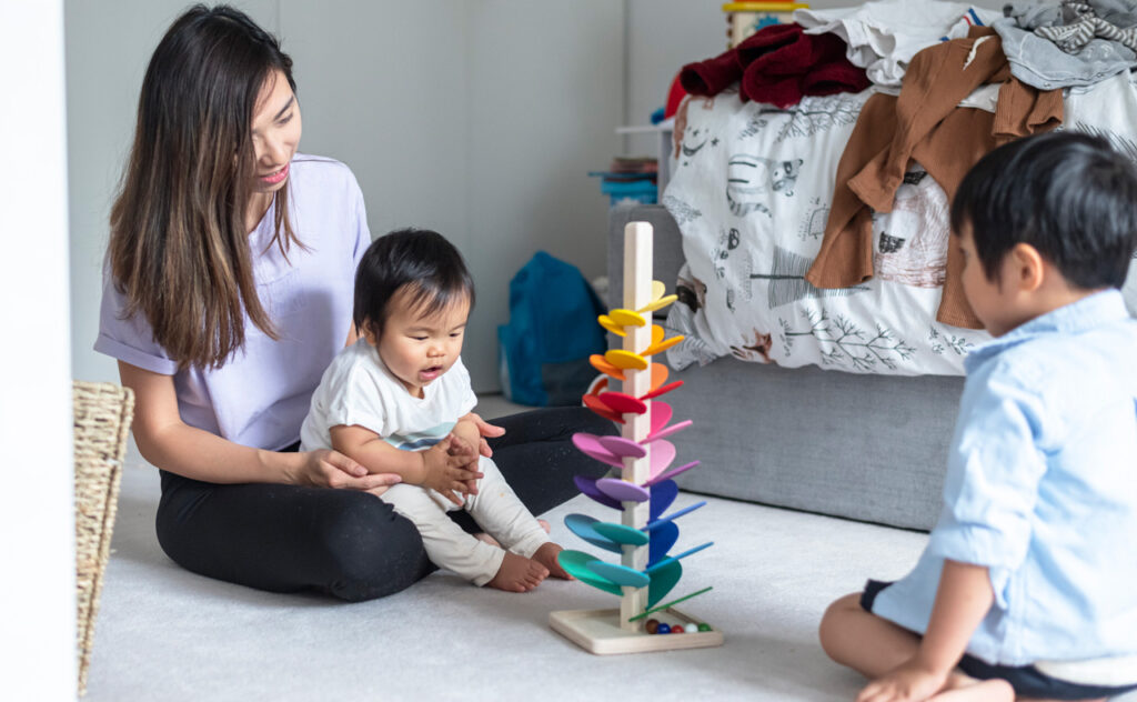 Mum playing with baby and toddler.