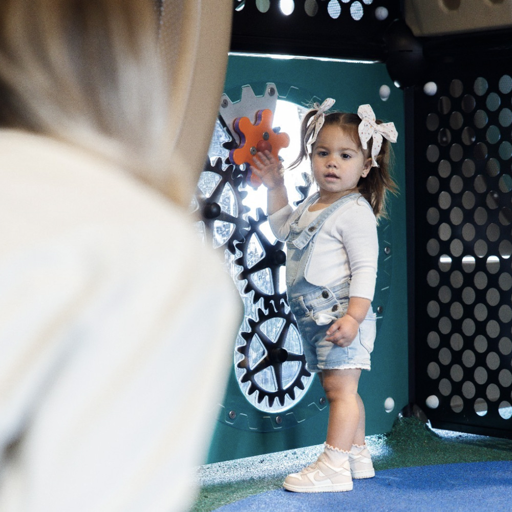 Small girl with ribbons plays in the children's area at The Willowdale Hotel.