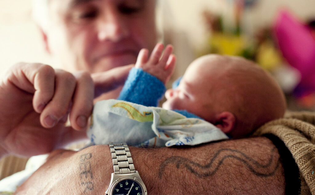 Grandfather nurses newborn grandson