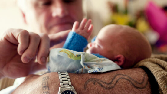 Grandfather nurses newborn grandson