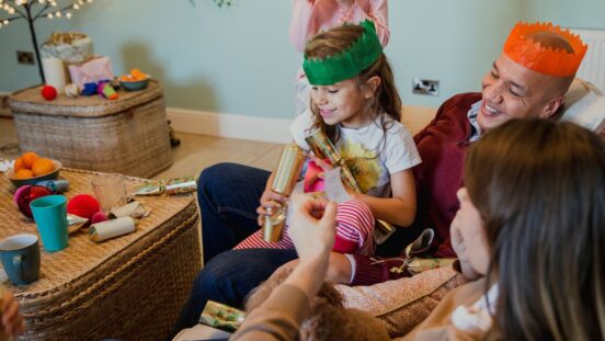 Family including young girl with a Christmas cracker