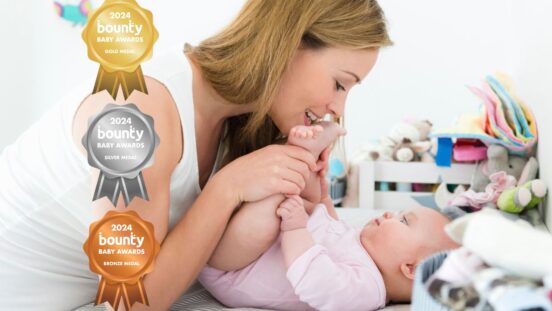 Mother playing with baby on changing table