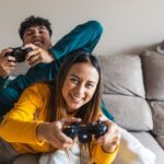 Two teens sitting on the lounge and gaming