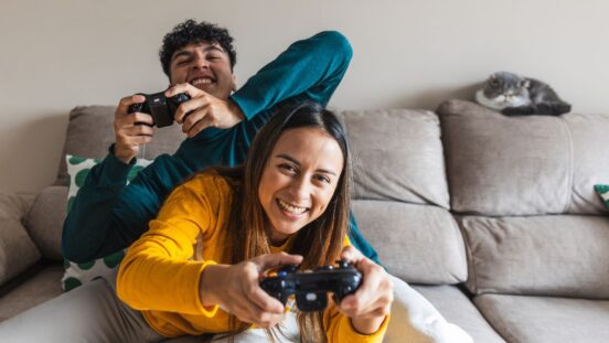 Two teens sitting on the lounge and gaming