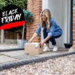 Woman picking up parcel from front door. Black Friday sales