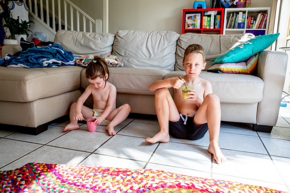 Australian mother of two young children in her family home participating in domestic life activities