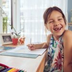 Young girl smiling while sitting at desk