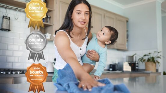 Mother holding baby while cleaning bench