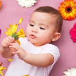 Spring baby names: Baby girl holding flower