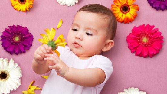 Spring baby names: Baby girl holding flower