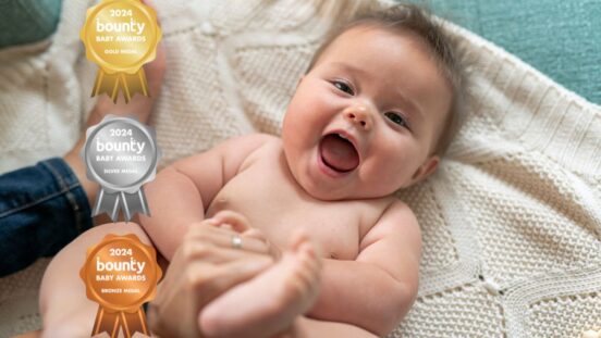 Bounty Baby Awards - fragrance free wipes: baby girl talking happily while playing with her mommy. The baby is wearing only a diaper and is looking directly at the camera.