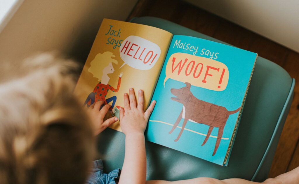 Kids hands on a picture book with words on it