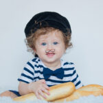 Little baby with moustache, beret and baguette on white background.