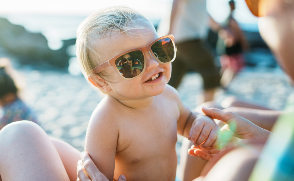 Blonde haired older baby wearing large trendy sunglasses