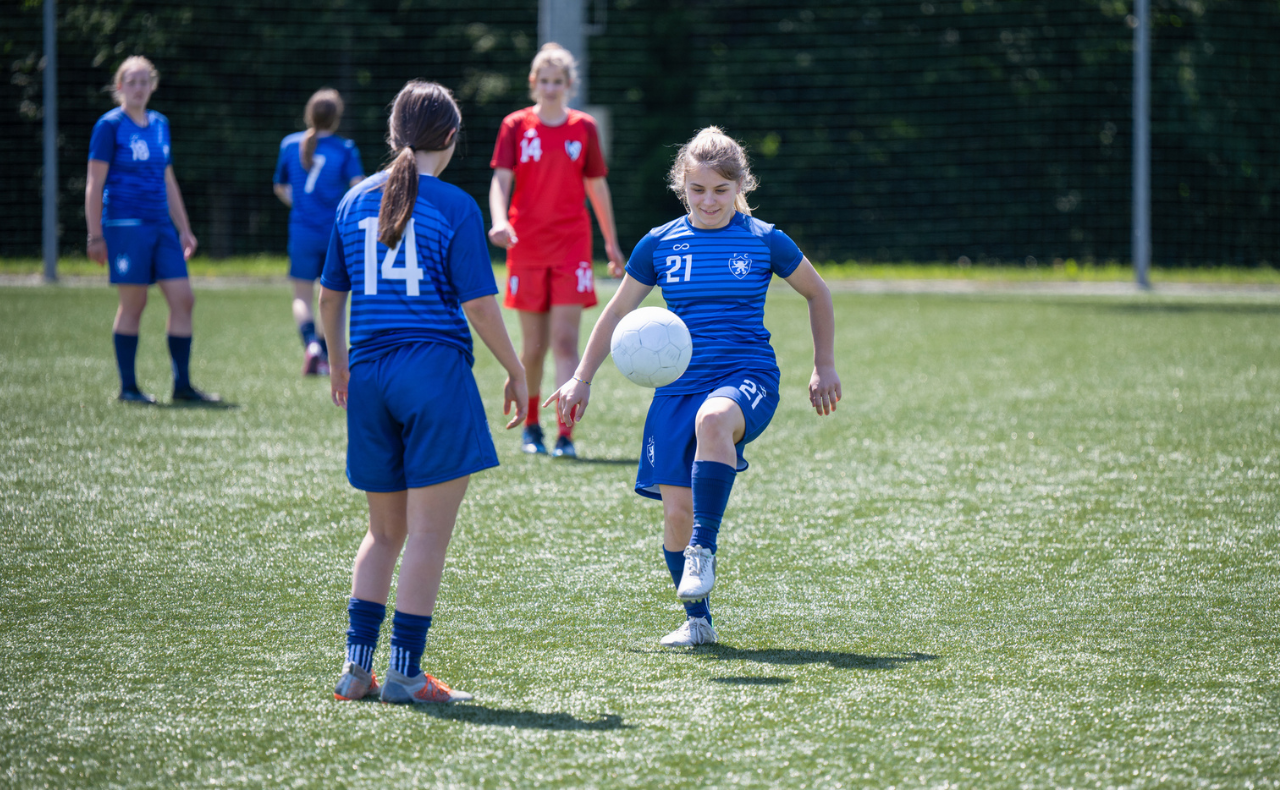 GIrls in blue soccer uniforms playing football