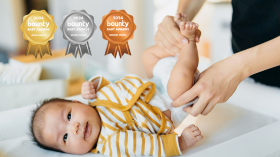 Cropped shot of young Asian mother changing her baby's nappy, with Gold, SIlver and Bronze Bounty Baby Awards badges on the image