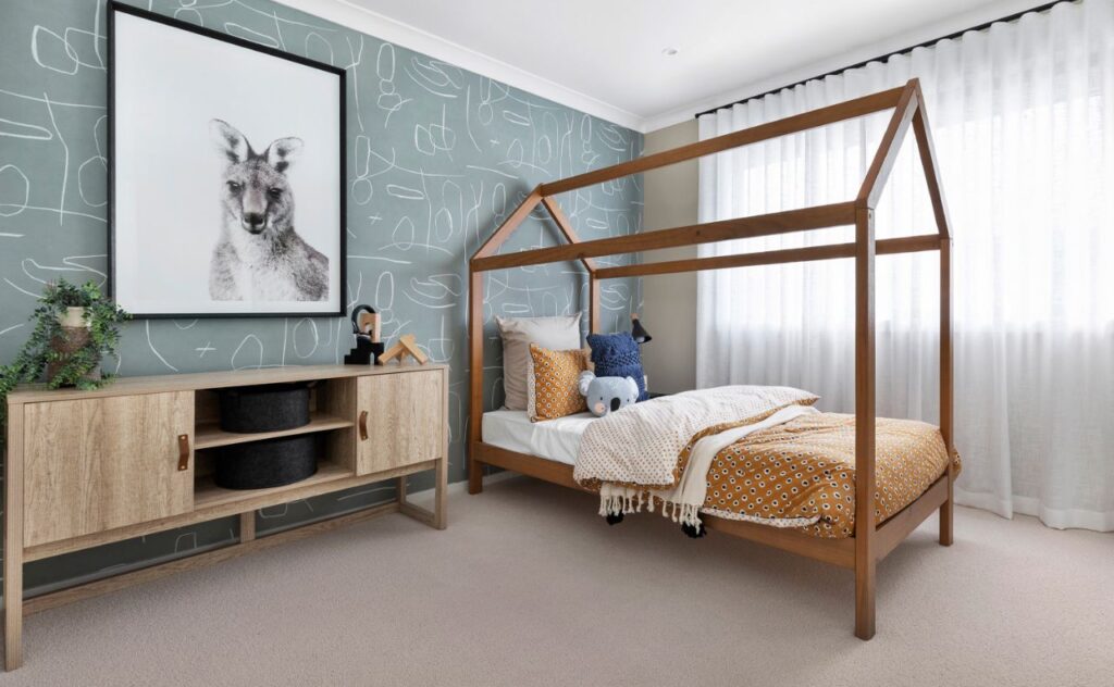 Child's open four-poster bed in neutral coloured, cosy nursery with a huge drawing of a kangaroo on the wall