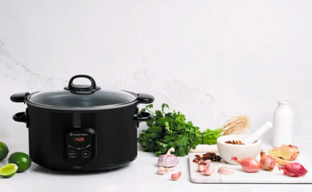 Russell Hobbs 6 Litre Searing Slow Cooker Matte Black in kitchen with food lifestyle image
