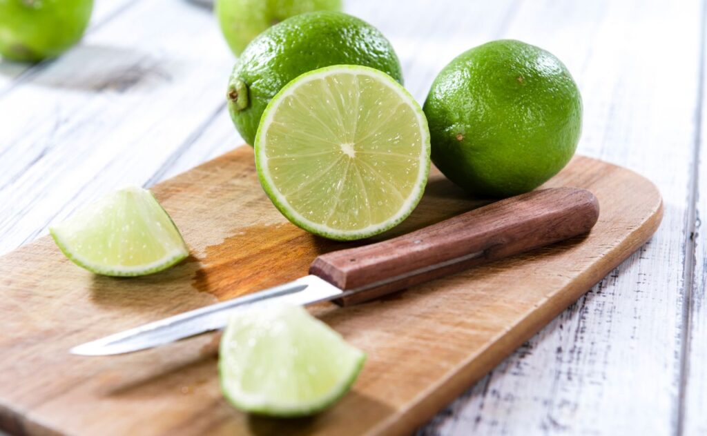 Limes cut up on chopping board