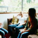 Father in discussion with daughters in living room