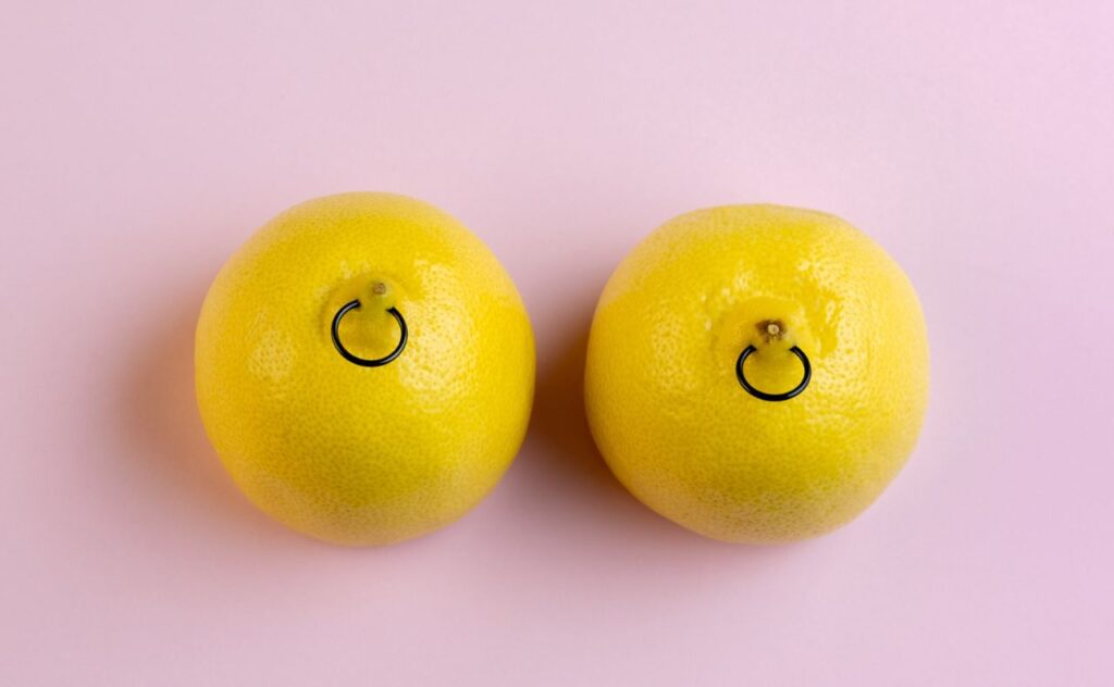 Two lemons with 'nipple' rings used to illustrate topic of topic of breastfeeding when you have nipple piercings